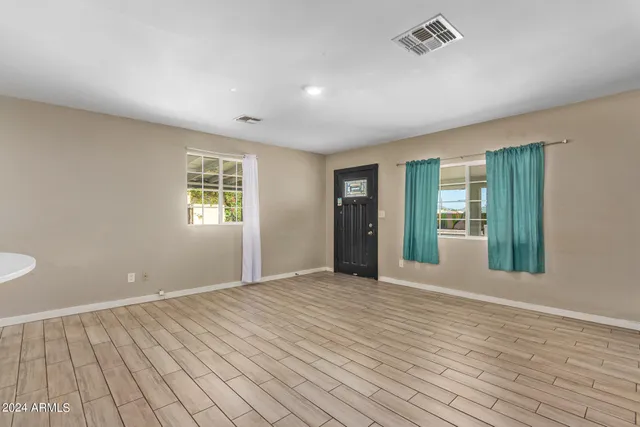 a view of kitchen with kitchen island stainless steel appliances cabinets and wooden floor