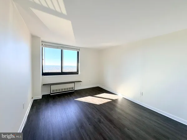 a view of empty room with wooden floor