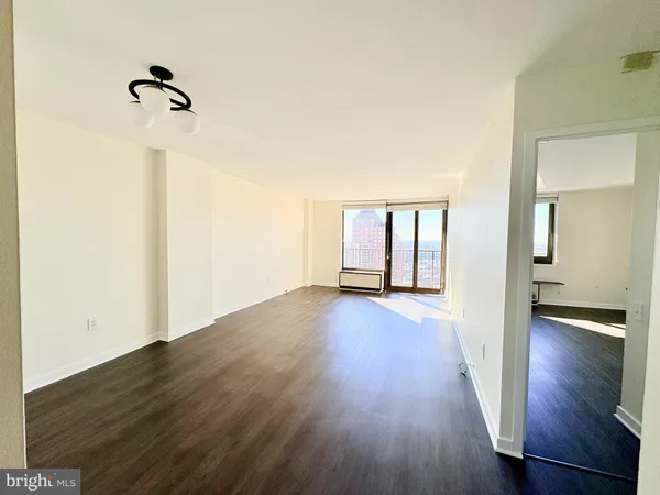 a view of empty room with wooden floor and ceiling fan