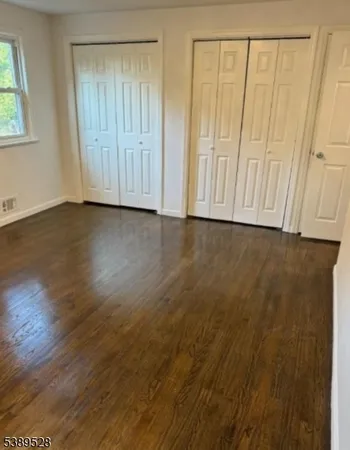 a view of a room that has wooden floor and window