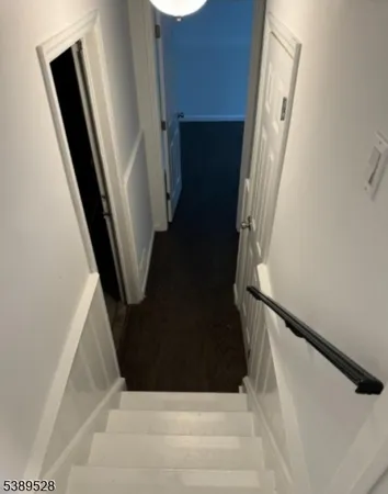 a view of staircase with white walls and railing