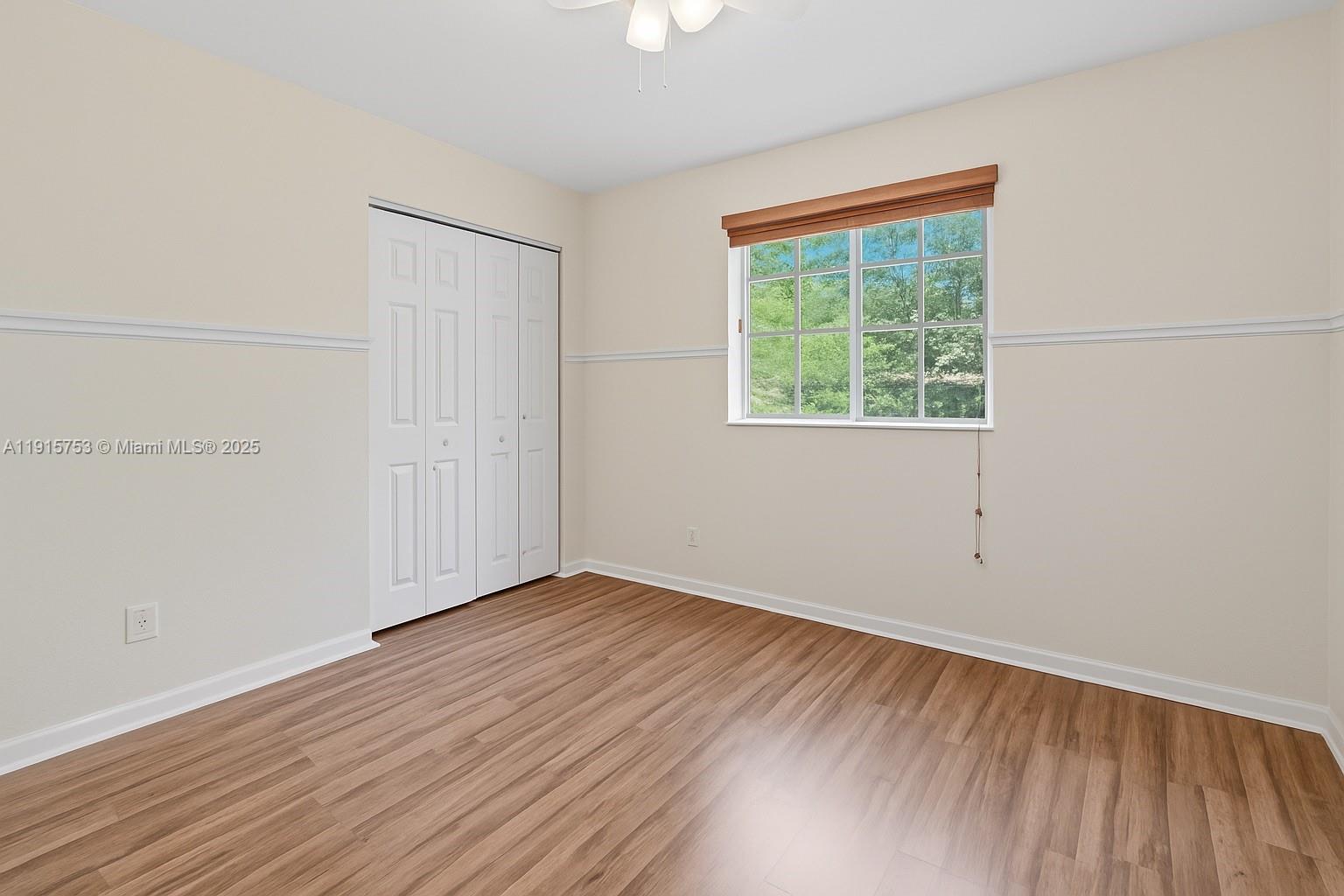 4581 Danson Way Delray Beach, FL 33445 - Photo 13 of 19 an empty room with wooden floor and windows