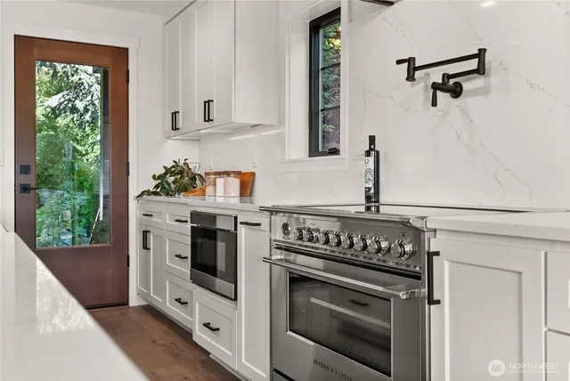 a kitchen with stainless steel appliances white cabinets and a stove