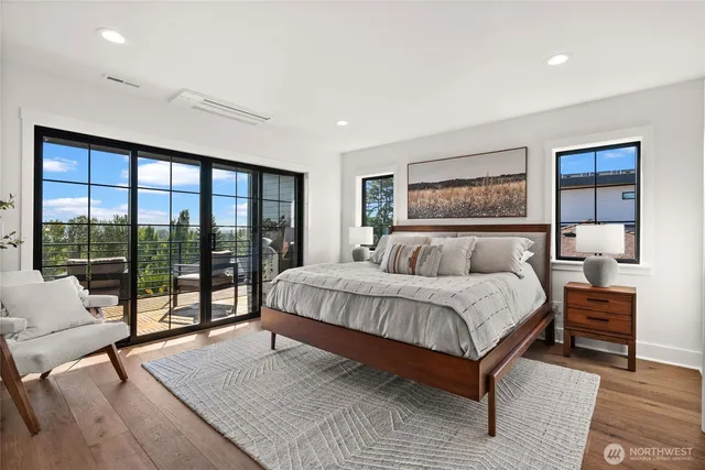 a spacious bedroom with a bed and glass window