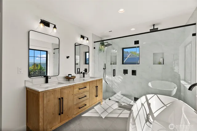 a spacious bathroom with double vanity a mirror and a shower