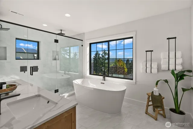 a bathroom with a tub a sink and a window