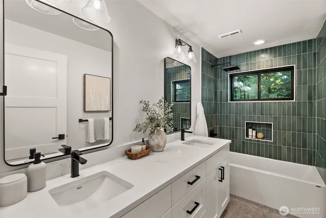 a bathroom with a double vanity sink mirror and bathtub