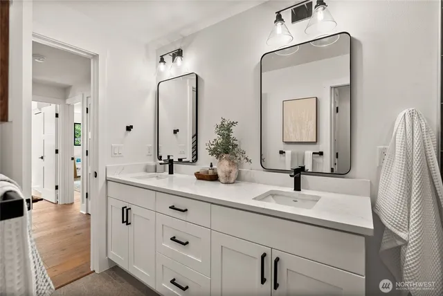 a bathroom with double vanity sinks and a mirror