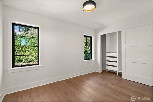an empty room with windows and closet