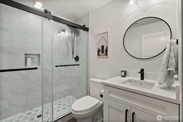 a bathroom with a toilet sink vanity and shower
