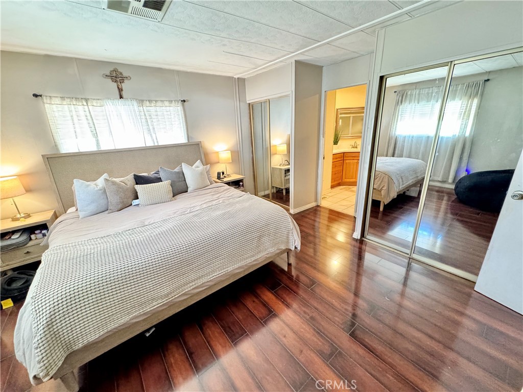 23301 Ridge Rte Drive, Unit 109 Laguna Hills, CA 92653 - Photo 25 of 46 a bedroom with bed and wooden floor