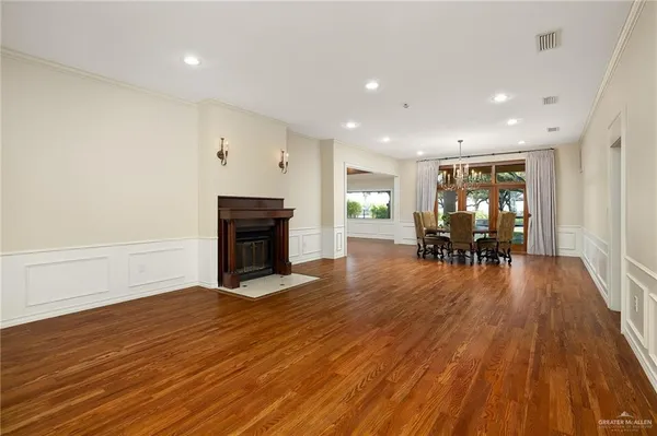 a view of a livingroom with furniture a fireplace wooden floor and a window