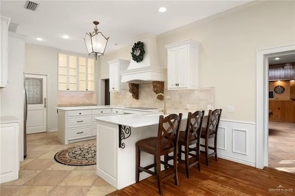 a kitchen with a dining table chairs and white cabinets
