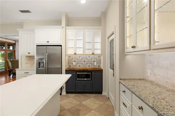 a kitchen with stainless steel appliances granite countertop a refrigerator and a sink