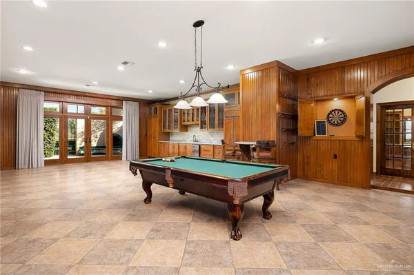 a room with pool table and glass windows