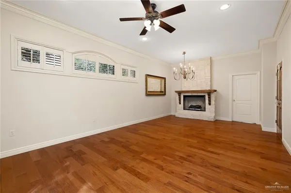 a view of an empty room with window and wooden floor
