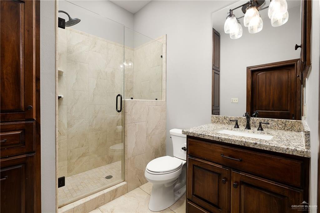 4725 Mile 6 Road McAllen, TX 78504 - Photo 38 of 45 a bathroom with a granite countertop sink a toilet and shower