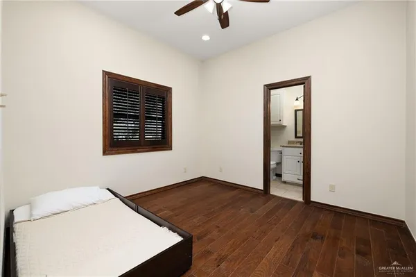 a bathroom with a granite countertop toilet sink shower and mirror