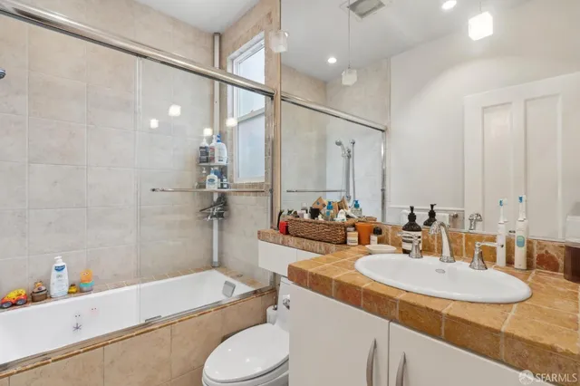 a bathroom with a granite countertop sink toilet and shower