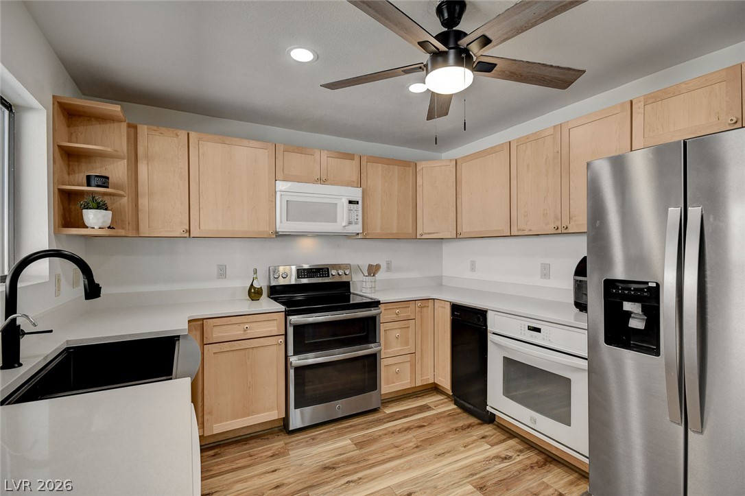 1920 Bowman Road Logandale, NV 89021 - Photo 26 of 68 Natural wood cabinetry paired with light countertops and modern appliances updates this cooking space.