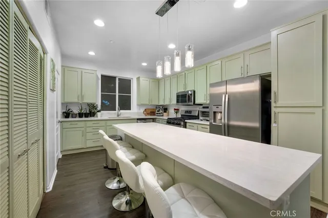 a kitchen with refrigerator and chairs