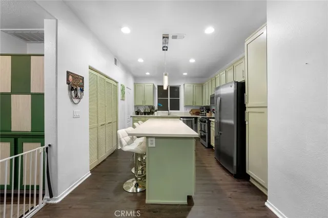 a kitchen with refrigerator and chairs