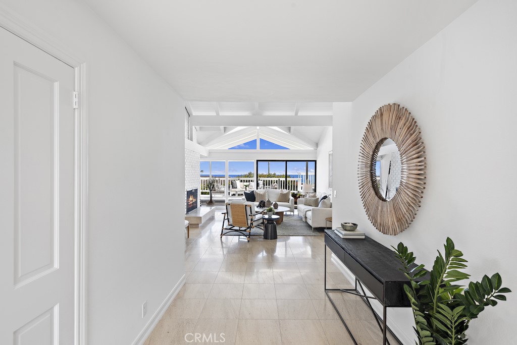 23242 Palawan Circle Dana Point, CA 92629 - Photo 4 of 34 a living room with furniture a chandelier a large window and a potted plant