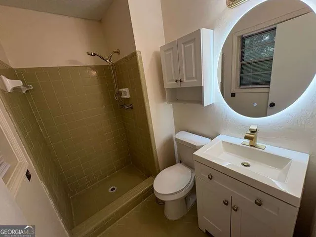 a bathroom with a sink mirror vanity and toilet