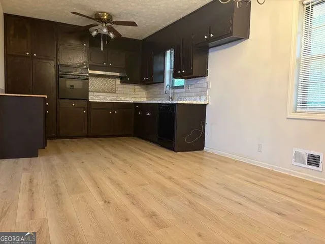 a kitchen with a sink appliances and cabinets