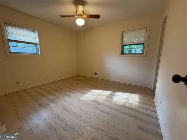 a view of empty room with wooden floor