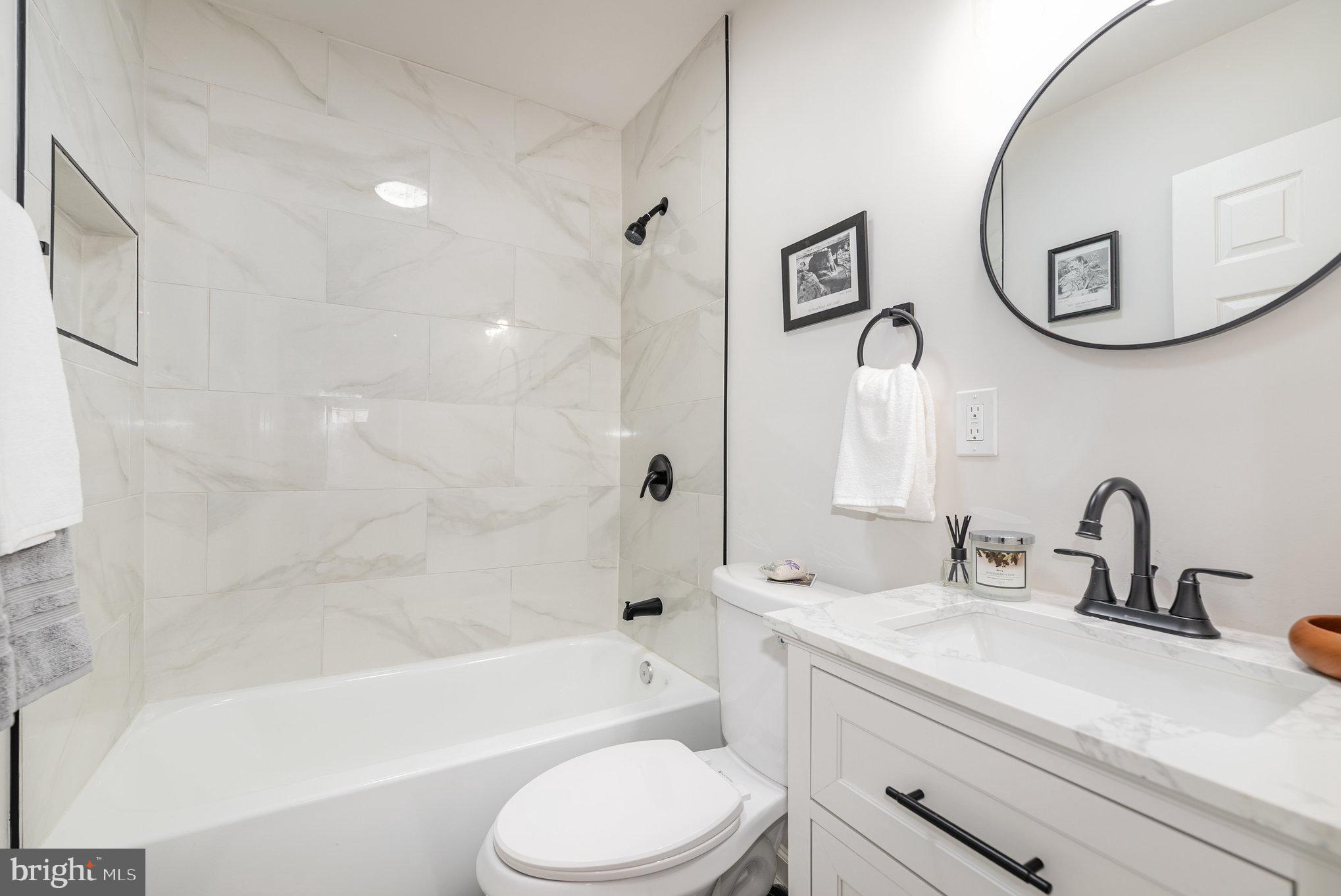 7 Terrace Road Essex, MD 21221 - Photo 18 of 25 a bathroom with a toilet a sink a mirror a bathtub and shower