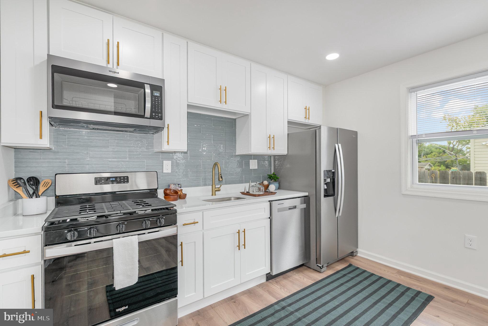 7 Terrace Road Essex, MD 21221 - Photo 7 of 25 a kitchen with stainless steel appliances a stove a microwave and a refrigerator