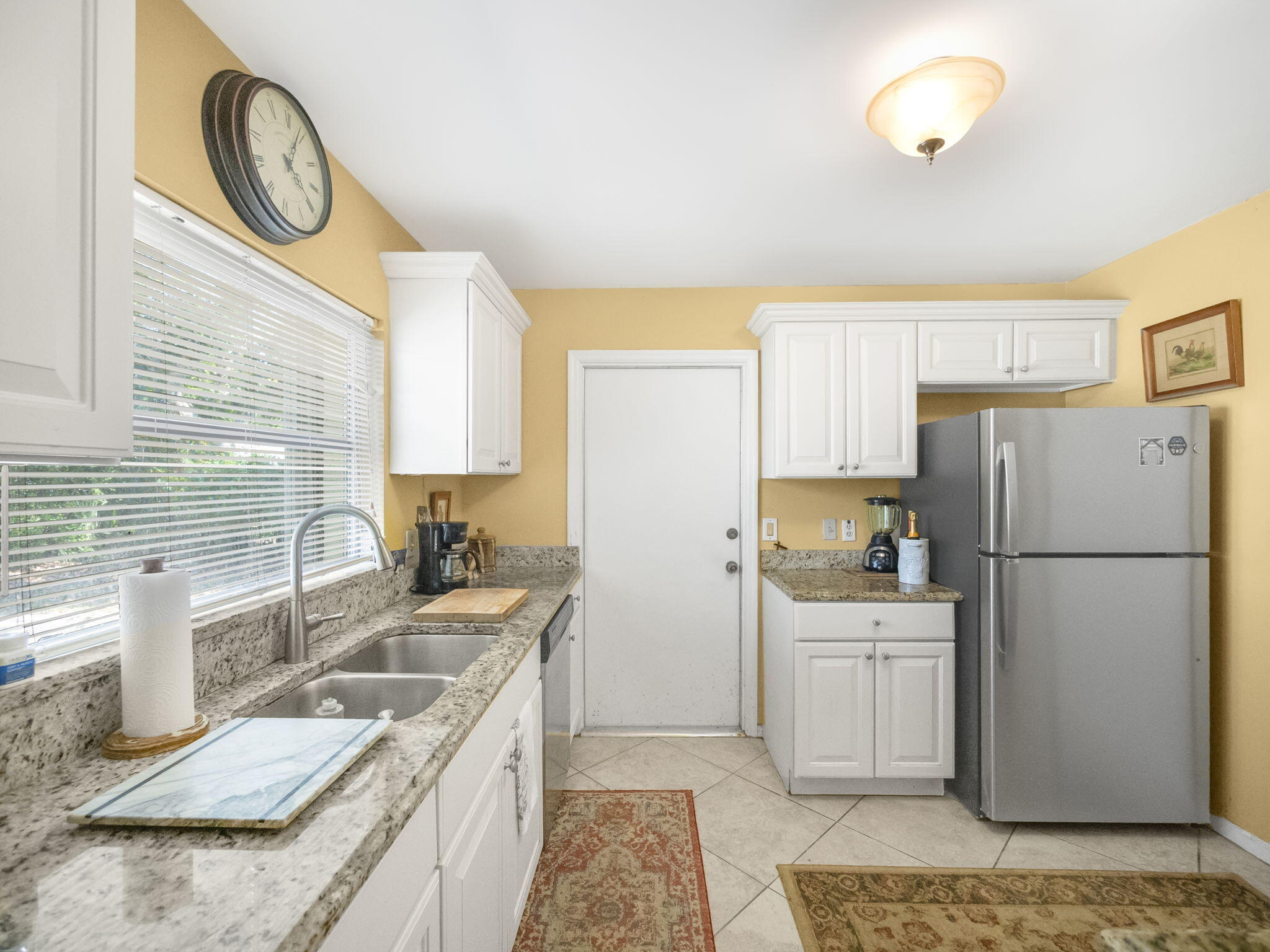 18390 Southeast Courtview Circle Jupiter, FL 33469 - Photo 4 of 16 a kitchen with a sink a stove a refrigerator cabinets and a window