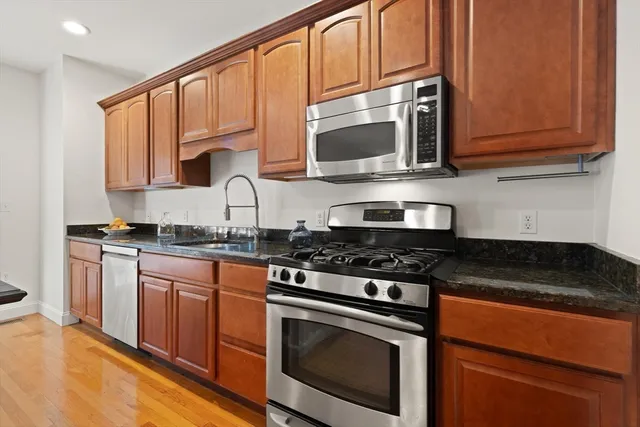 a kitchen with appliances a sink and cabinets