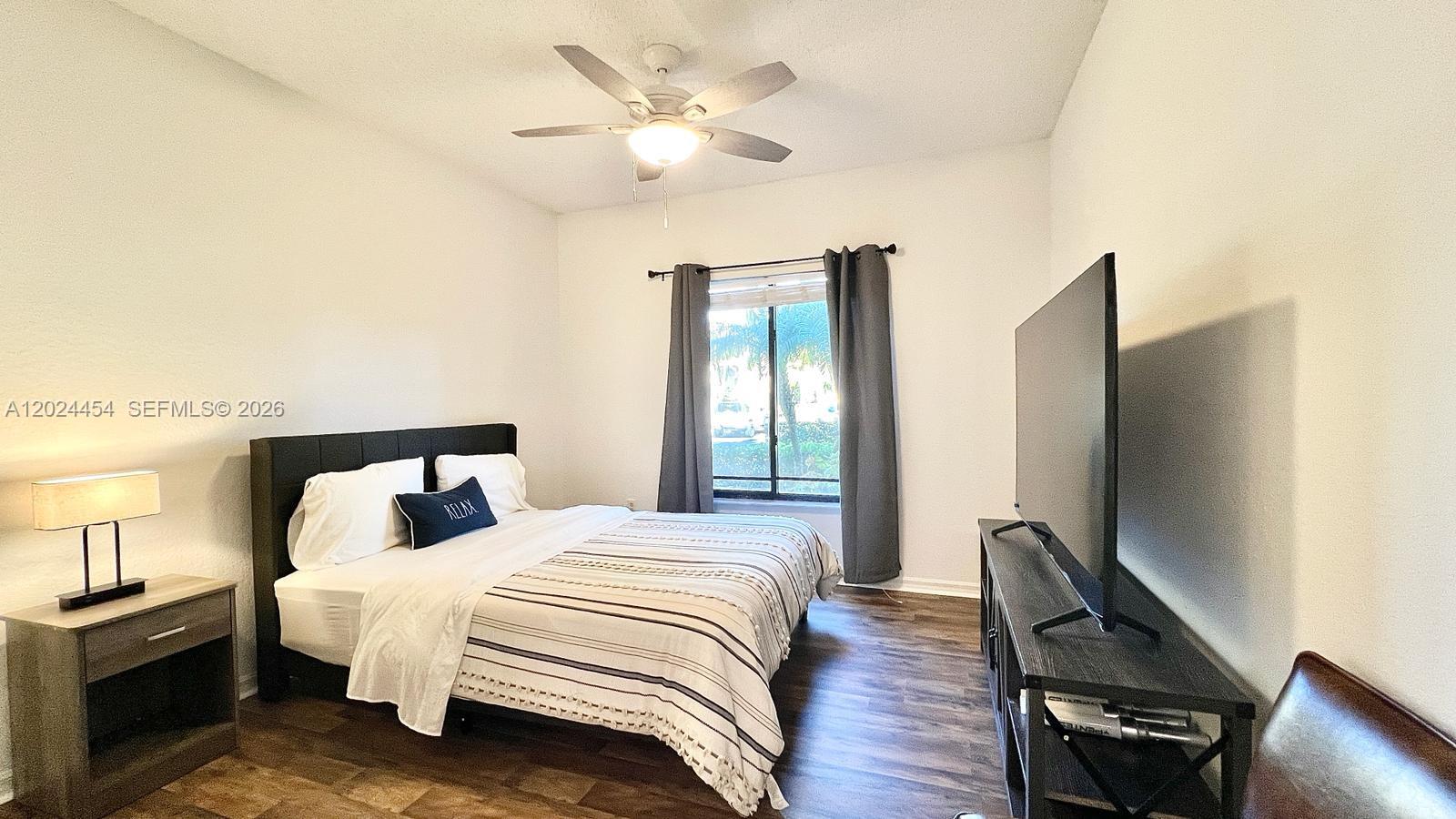2727 Anzio Court, Unit 106 Palm Beach Gardens, FL 33410 - Photo 14 of 43 a bedroom with a bed and a chandelier