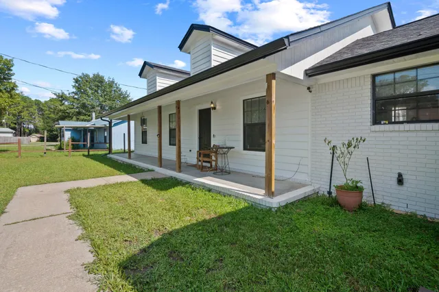 a view of a house with backyard and sitting area