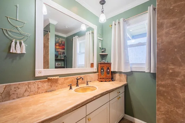 a bathroom with a granite countertop sink and a mirror