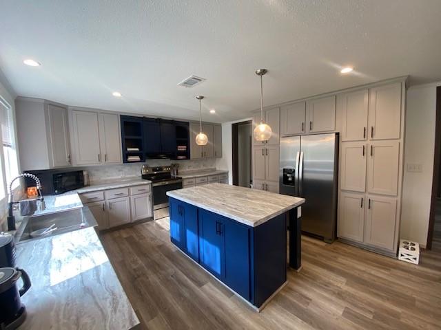 12154 County Road 331A Terrell, TX 75161 - Photo 9 of 31 a kitchen with stainless steel appliances granite countertop a refrigerator a sink dishwasher a stove and a oven with wooden floor