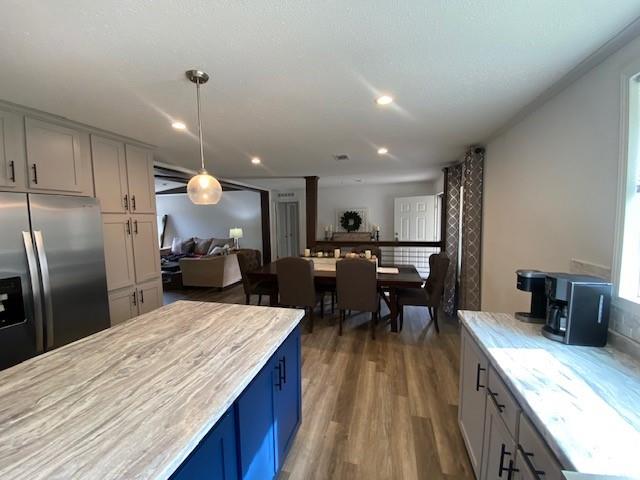 12154 County Road 331A Terrell, TX 75161 - Photo 10 of 31 a kitchen with stainless steel appliances kitchen island granite countertop a kitchen island a stove a refrigerator a sink a dining table and chairs with wooden floor