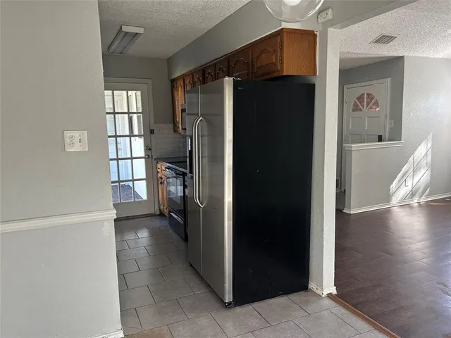 a view of a refrigerator in kitchen and a windows