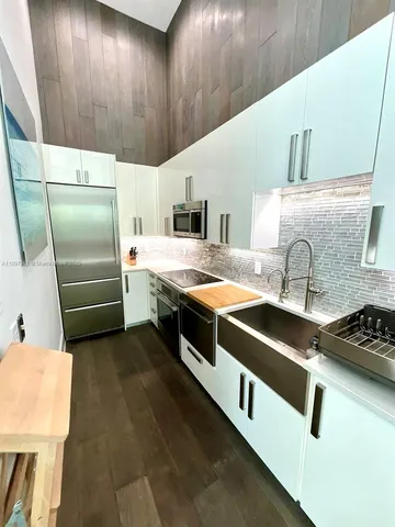 a kitchen with stainless steel appliances a stove a sink and a refrigerator