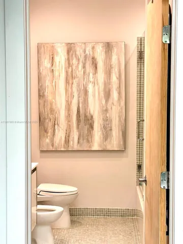 a bathroom with a toilet and a shower curtain