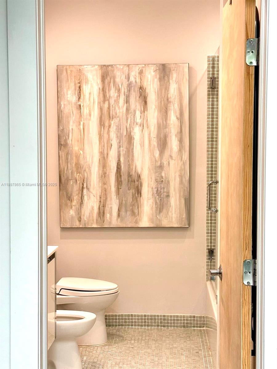 221 Jefferson Avenue, Unit 4 Miami Beach, FL 33139 - Photo 23 of 34 a bathroom with a toilet and a shower curtain