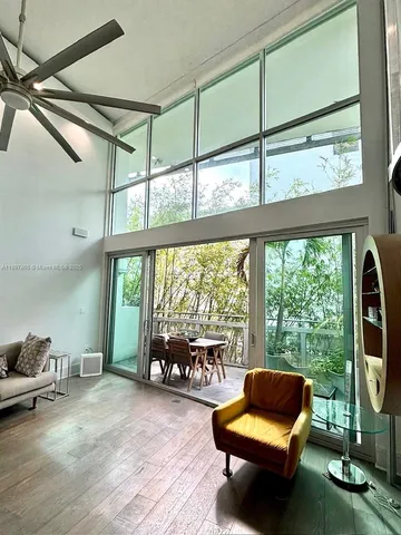 a living room with furniture and a floor to ceiling window