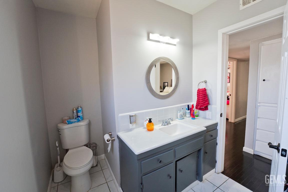 Undisclosed Address Bakersfield, CA 93306 - Photo 15 of 20 a bathroom with a toilet sink vanity and mirror