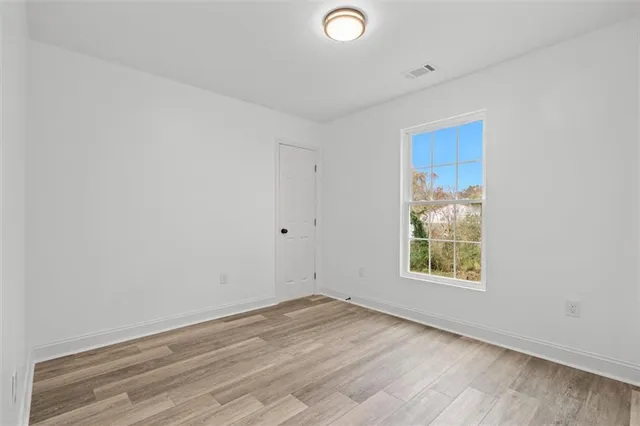 a view of empty room with wooden floor