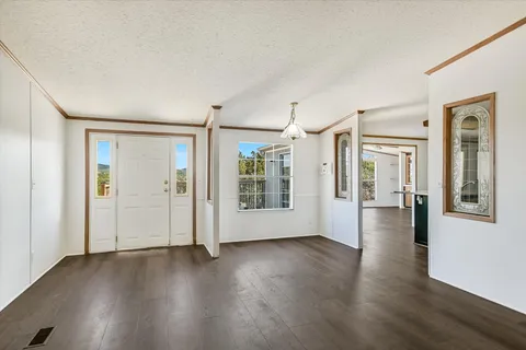 a view of a big room with wooden floor and windows