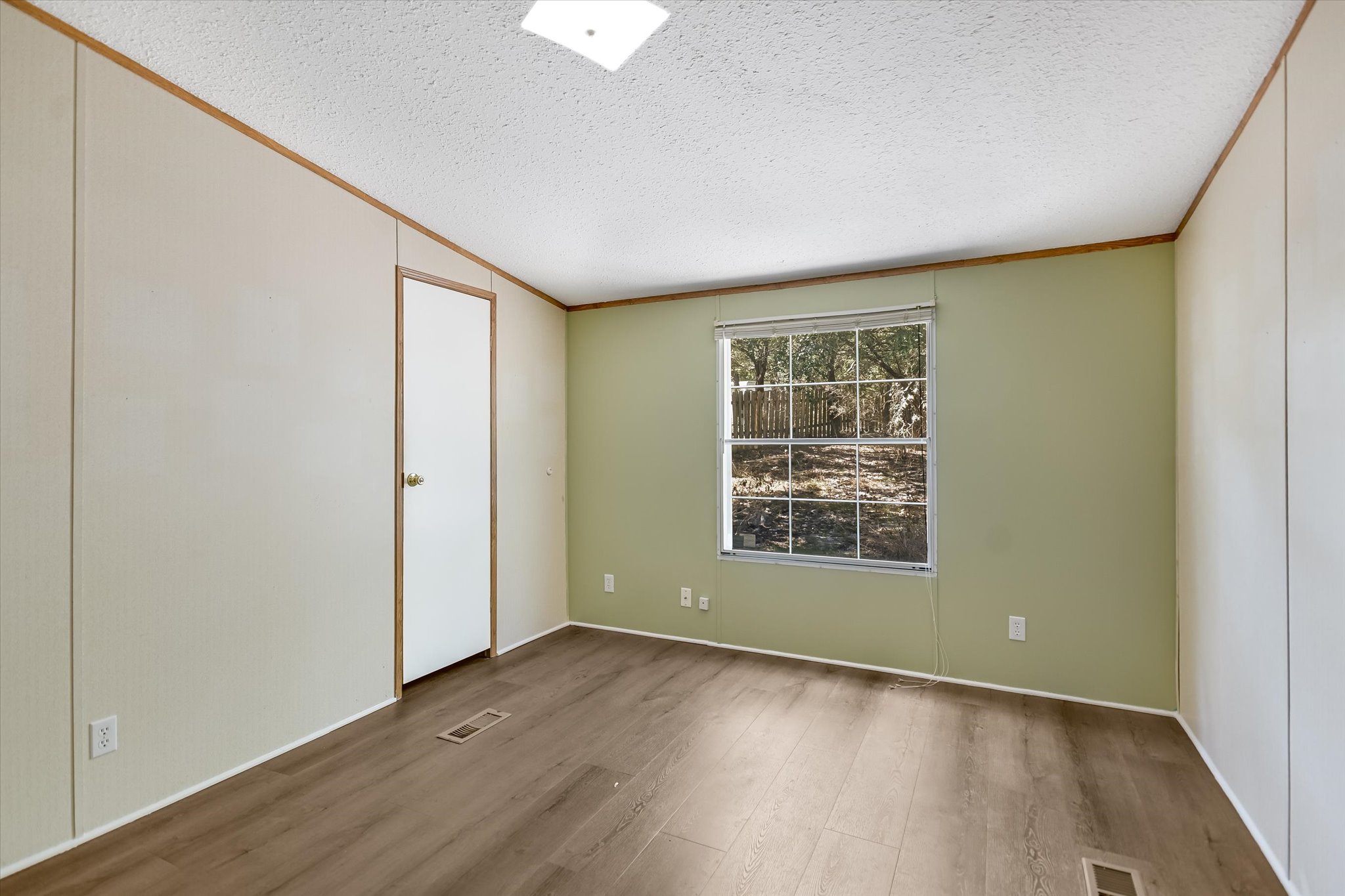 217 Rousey Street Canyon Lake, TX 78133 - Photo 22 of 25 an empty room with wooden floor and windows