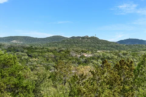a view of a mountain range with lush green forest