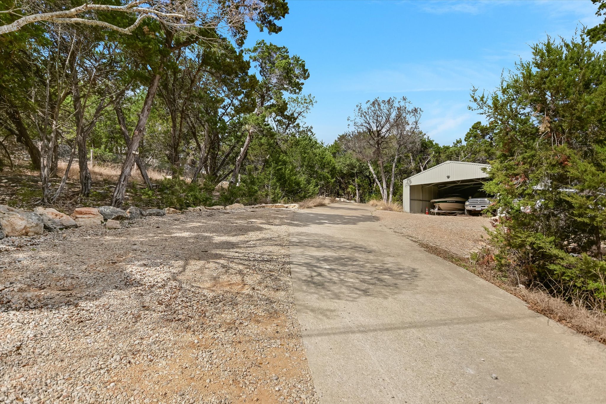 217 Rousey Street Canyon Lake, TX 78133 - Photo 4 of 25 a backyard of a house with large trees and outdoor seating